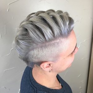 A woman with grey hair is wearing a short haircut.