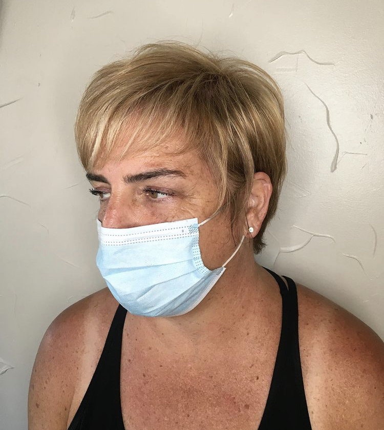 A woman wearing a face mask and looking at the camera.